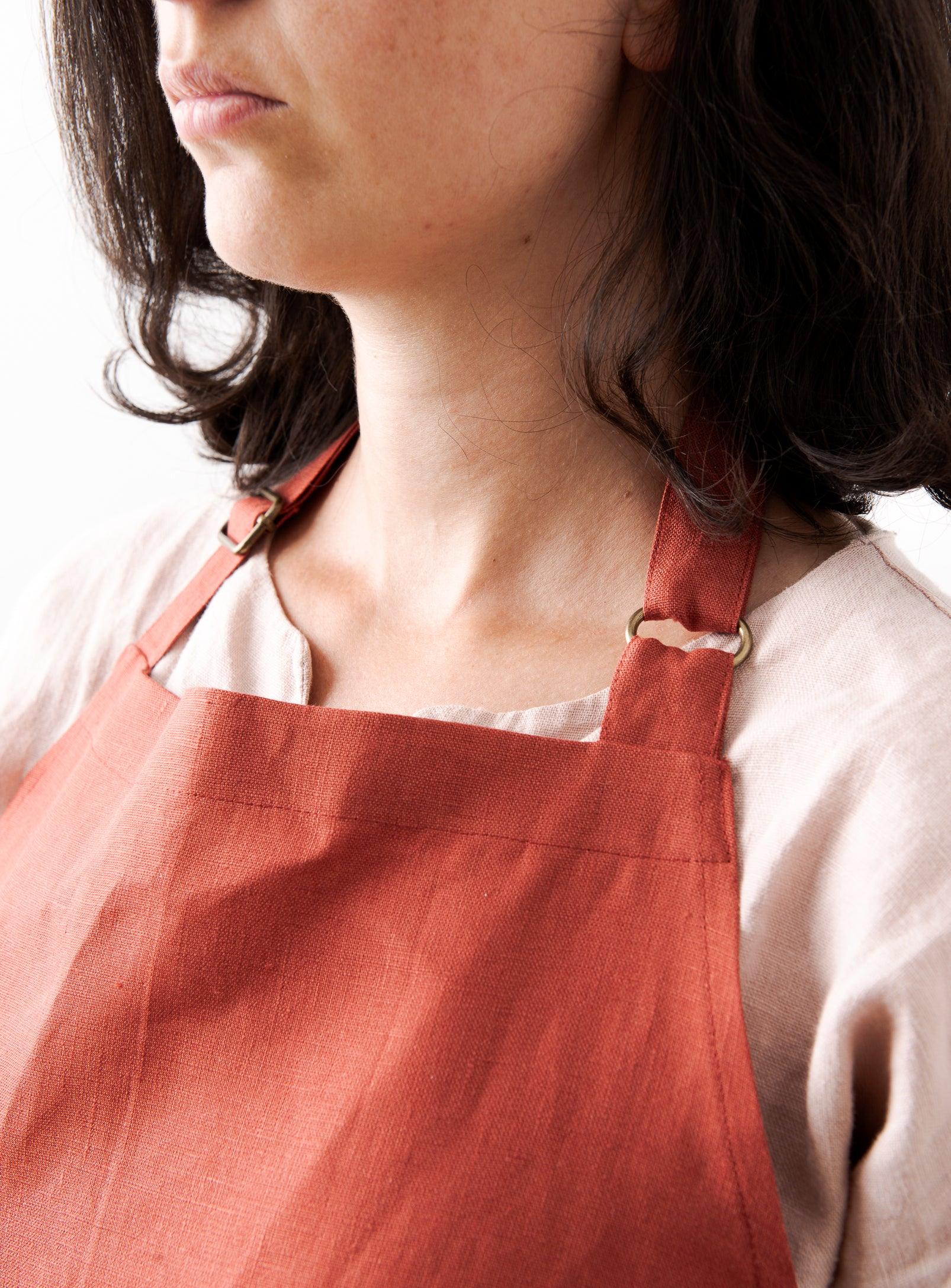close-up view of a red apron adjustable on the neck with metal sliders