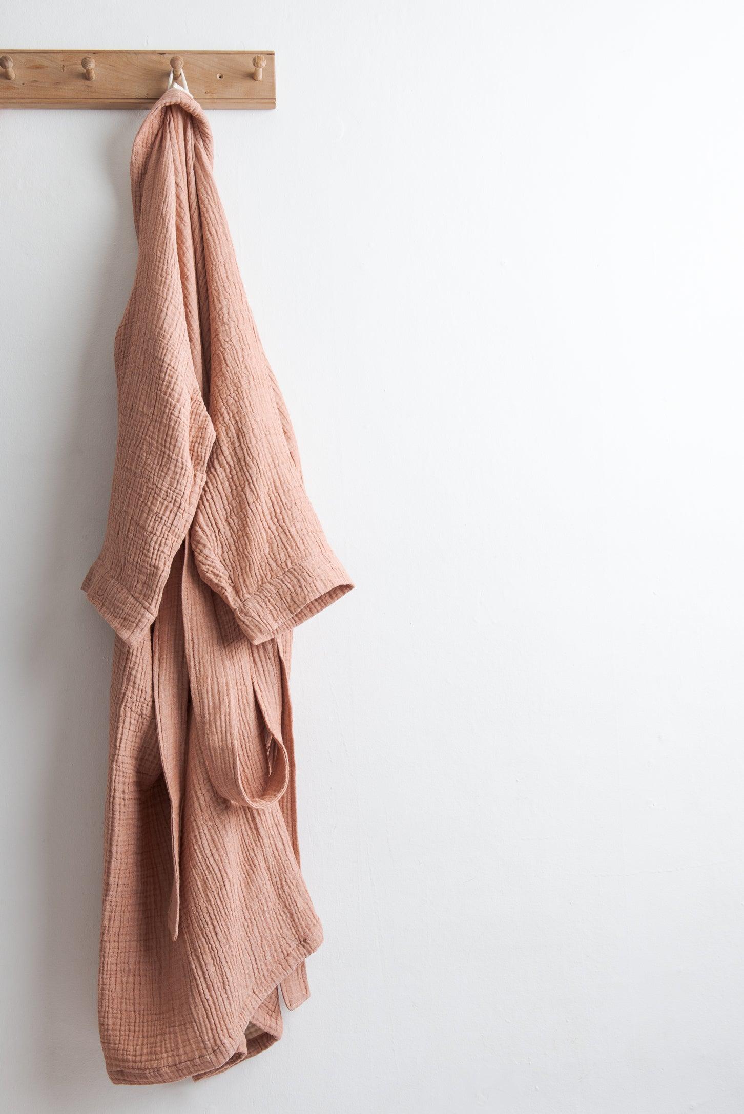 pink coloured cotton robe hung on a hook