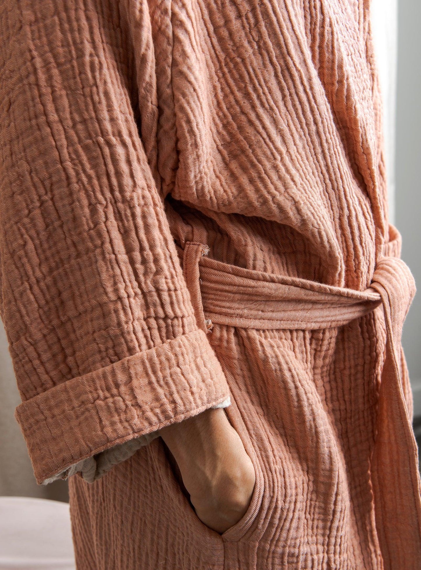 woman's hand in a pocket of a pink loungewear