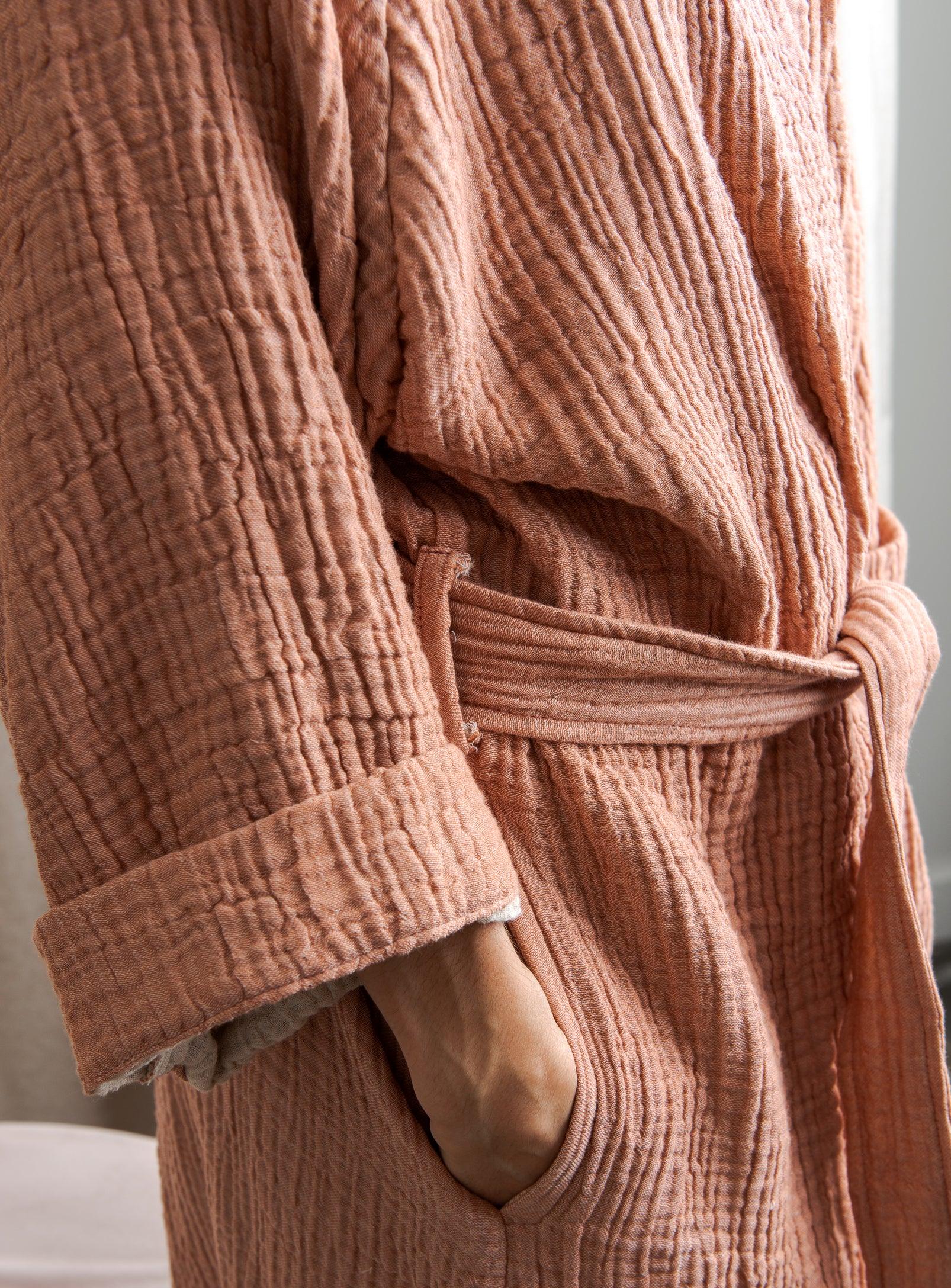 woman's hand in a pocket of a pink loungewear
